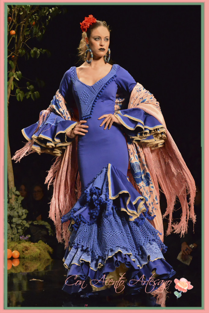 Traje de flamenca azul eléctrico con volantes de crochet y madroños de Aurora Gaviño