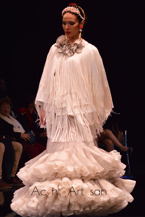 Traje de flamenca blanco de lunares y abrigo flecado de Cristina Vázquez