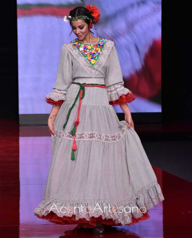Traje de flamenca gris y rojo con aplicaciones de flores en el escote de Atelier Rima 
