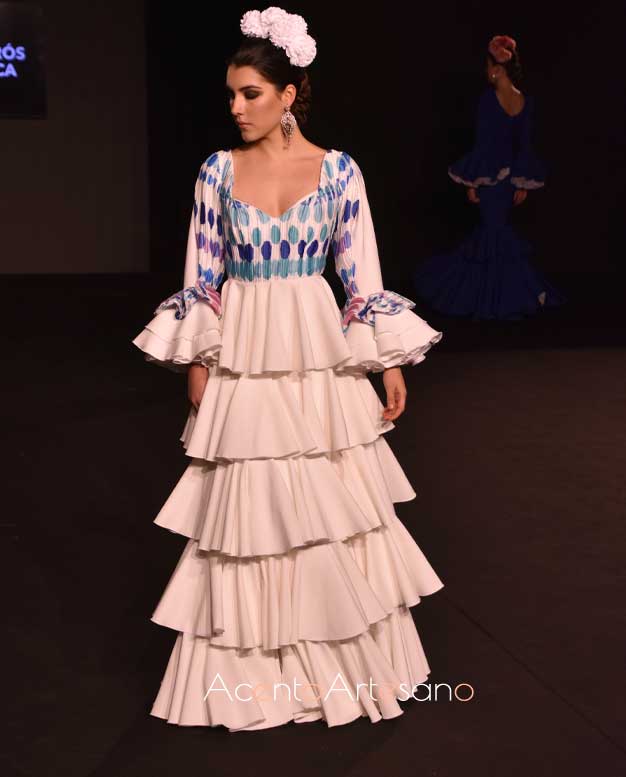 Vestido de flamenca de talle alto, por lo que los volantes empiezan en cintura en tono blanco de Merche Caparrós