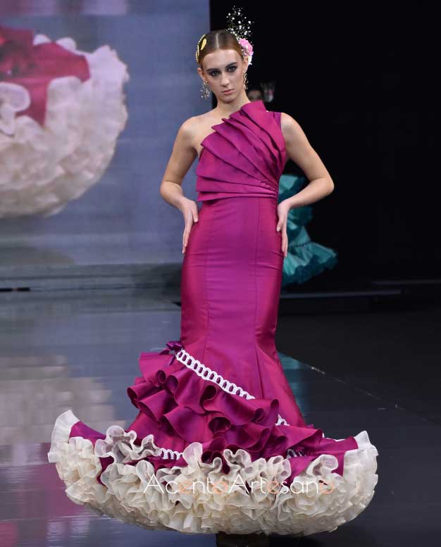 Traje de flamenca buganvilla con escote asimétrico y pasacintas ancho de Lorena Velázquez